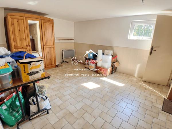 Vue sur la terrasse sous le préau et le jardin