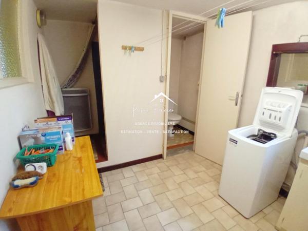 Vue sur la terrasse sous le préau et le jardin