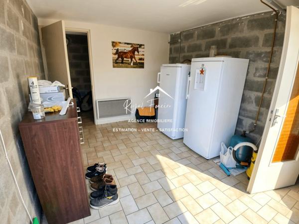 Vue sur la terrasse sous le préau et le jardin