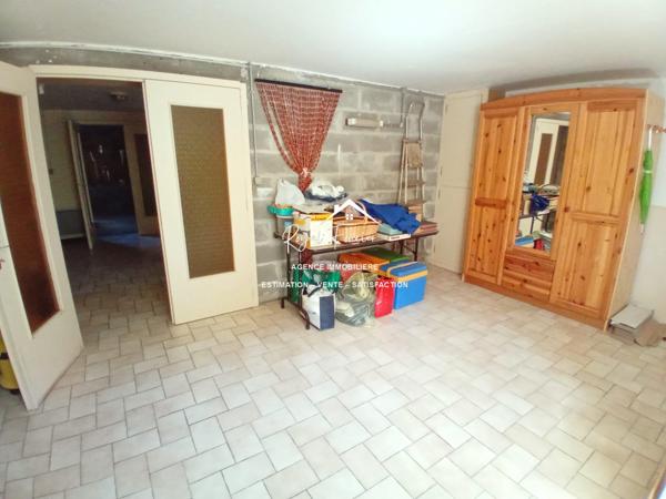 Vue sur la terrasse sous le préau et le jardin