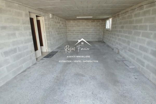 Vue sur la terrasse sous le préau et le jardin