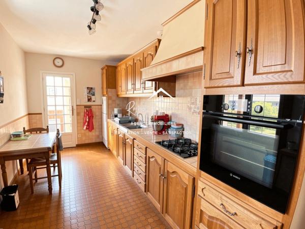 Vue sur la terrasse sous le préau et le jardin