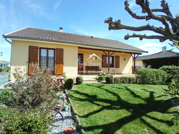 Vue sur la terrasse sous le préau et le jardin