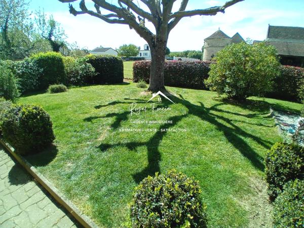 Vue sur la terrasse sous le préau et le jardin