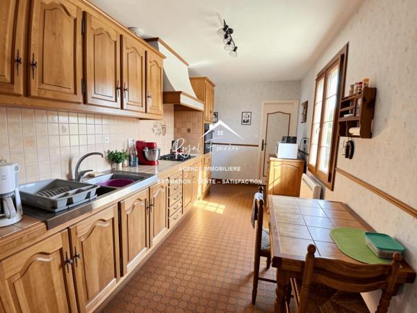 Vue sur la terrasse sous le préau et le jardin