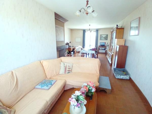 Vue sur la terrasse sous le préau et le jardin