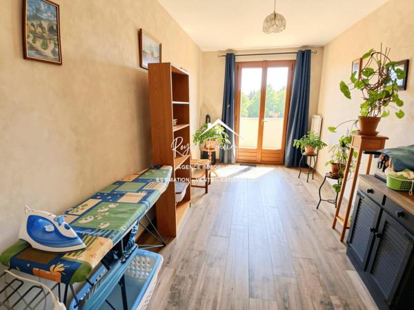 Vue sur la terrasse sous le préau et le jardin