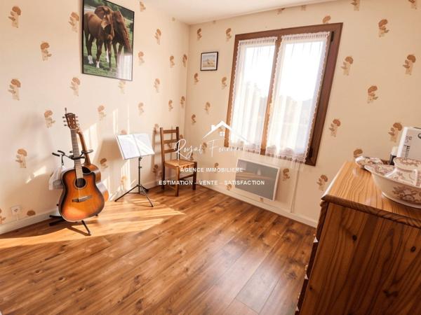 Vue sur la terrasse sous le préau et le jardin