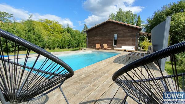 Maison en bois avec jardin et piscine.