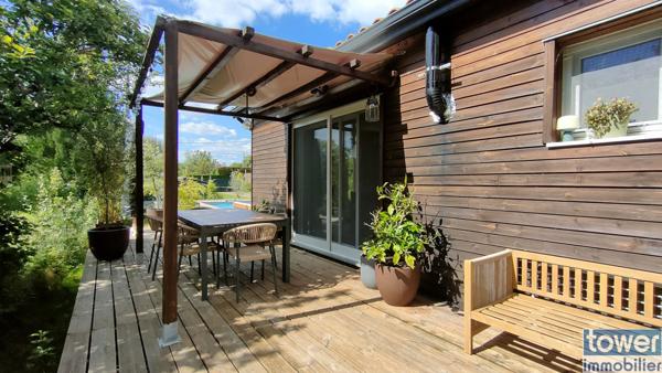 Maison en bois avec jardin et piscine.