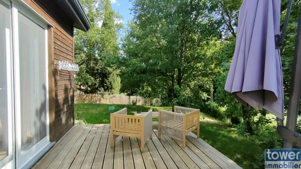Maison en bois avec jardin et piscine.