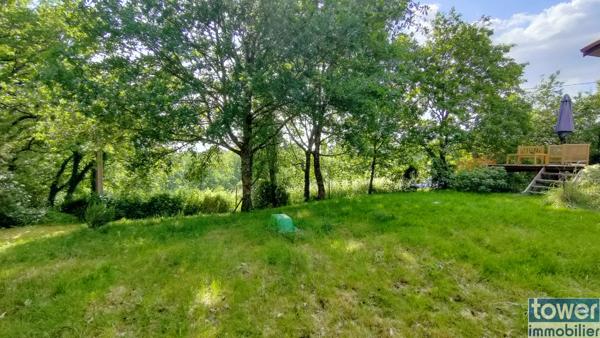 Maison en bois avec jardin et piscine.