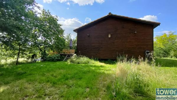 Maison en bois avec jardin et piscine.