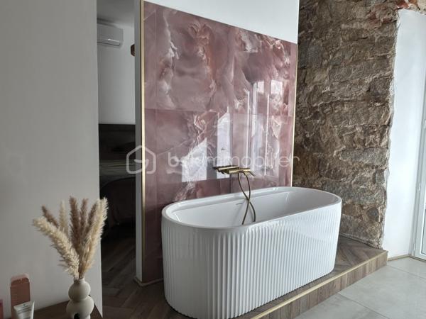 AJACCIO - Votre conseillère BSK Immobilier a le plaisir de vous proposer un lieu singulier où l’âme de l’ancien rencontre le raffinement d’une rénovation d’exception.
Au cœur de l’hyper-centre ajaccien, à deux pas de la rue Fesch et du cours Napoléon, se dévoile ce magnifique appartement T2 de 51 m², entièrement rénové avec des matériaux de grande qualité.
Dès l’entrée, le charme opère. Les pierres apparentes, les voûtes anciennes et les belles hauteurs sous plafond confèrent à ce lieu une identité rare, empreinte d’authenticité et de caractère. Les volumes généreux et les grandes fenêtres apportent une agréable sensation d’espace et de lumière, sublimant le contraste entre l’histoire des lieux et l’élégance d’une rénovation contemporaine.

La pièce de vie accueille une cuisine équipée Veneta Cucine, ouverte sur un séjour chaleureux agrémenté d’une cheminée. Un espace convivial où le cachet de l’ancien s’accorde harmonieusement avec le confort moderne. La chambre, dotée d’un grand dressing, prolonge cette atmosphère singulière.
Mais la véritable signature de cet appartement se révèle également dans sa magnifique salle de bains. Ses revêtements muraux en onyx rose apportent une touche de sophistication et de lumière, créant un contraste saisissant avec la pierre ancienne et les voûtes. La douche à l’italienne et la baignoire viennent parfaire cet espace dédié au confort et au bien-être, où les matériaux nobles deviennent de véritables éléments de décoration.
Un WC aménagé en espace buanderie ainsi qu’une loggia avec placard complètent les prestations.
À l’extérieur, la loggia s’ouvre sur une cour arborée, offrant une parenthèse de verdure et de fraîcheur particulièrement appréciable en plein centre-ville.

Prestations : Climatisation réversible Bosch, volets roulants solaires dans la chambre et la salle de bains, onyx rose, parquet, carrelages, menuiseries bois et alu, double-vitrages, une architecture atypique : pierres apparentes, voûtes et belles hauteurs sous plafond, cuisine équipée Veneta Cucine, douche à l’italienne et baignoire, une chambre avec grand dressing

Un emplacement privilégié, à proximité immédiate des commerces, services et transports. La plage est à environ 800 mètres
DPE : C | GES : A
Bien plus qu’un appartement, un lieu de caractère où chaque matière raconte une histoire. L’authenticité des vieilles pierres, le charme des voûtes et la délicatesse de l’onyx rose composent une alliance esthétique singulière, pour un intérieur qui ne ressemble à aucun autre.

Un bien rare au cœur d’Ajaccio, pour les amateurs de charme, d’élégance et d’architecture atypique, souhaitant profiter pleinement de la vie citadine tout en bénéficiant d’un intérieur empreint de personnalité. Idéal résidence principale, pied à terre ou investissement locatif.

Pour toute information et visite contactez Pierrine MURRONI 0617092828