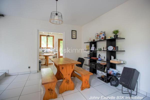 Venez découvrir cette maison atypique des années 1900 d’environ 105 m², édifiée sur une parcelle d’environ 430 m².

La maison vous accueille par une entrée ouverte sur une salle à manger, un salon avec cheminée fonctionnelle ainsi qu’une cuisine donnant directement accès au jardin situé à l’arrière de la maison.

Dès que l’on arrive sur la terrasse, l’atmosphère change complètement. Le jardin arboré, la verdure omniprésente et le calme qui s’en dégage donnent une véritable sensation de déconnexion. Un lieu agréable à vivre où l’on imagine facilement les repas d’été, les moments en famille ou simplement profiter du silence et de la nature.

À l’étage, la maison dispose de 3 chambres ainsi que d’une salle d’eau avec WC intégré. Les combles aménagés offrent également un bel espace complémentaire idéal pour un bureau, une salle TV ou une chambre d’appoint.

Un garage fermé ainsi qu’une cave complètent ce bien de caractère. Maison mitoyenne située à proximité des commerces, écoles et lignes de bus (1511, 1512 et 1517), à seulement 10 minutes du centre-ville.

Une maison avec une véritable âme, idéale pour les acquéreurs recherchant avant tout un cadre de vie paisible et chaleureux.