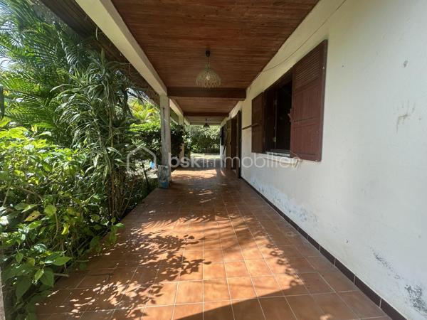 Située au 8ᵉ à La Montagne, dans un quartier résidentiel calme, cette maison à rénover de 161 m² habitables est implantée sur une parcelle de 914 m² arborée, à proximité immédiate du village, des commerces (supermarché, boulangerie, pharmacie), des écoles et des principaux axes.

La maison se compose, au rez-de-chaussée, d’un séjour de 28 m² offrant un bel espace de vie ainsi que de trois grandes chambres aux volumes confortables. Son agencement permet d’envisager différents projets de rénovation et d’aménagement selon vos besoins.

À l’extérieur, une varangue de 28 m² prolonge les espaces de vie et donne sur un terrain planté de letchis, de canneliers et d’ylang-ylang. Une allée permet de stationner plusieurs véhicules sur la propriété.

Le bien est équipé d’un chauffe-eau solaire et l’assainissement est assuré par une fosse septique.

Le montant de la taxe foncière est de 2400€.

Cette maison constitue une belle opportunité pour les acquéreurs souhaitant rénover un bien spacieux, bénéficiant d’un grand terrain et d’un emplacement recherché à La Montagne.