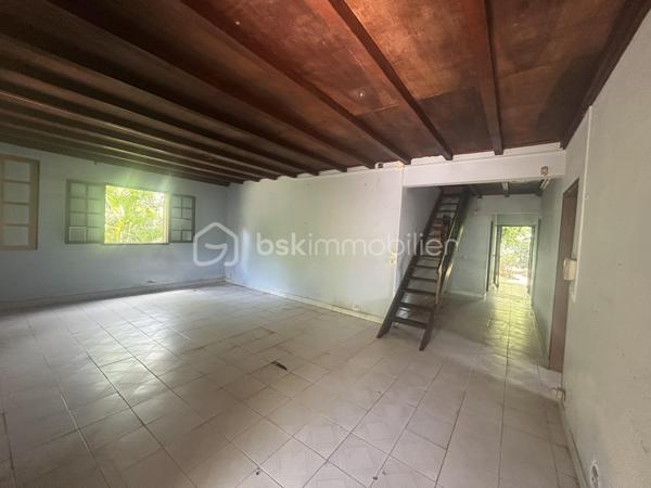 Située au 8ᵉ à La Montagne, dans un quartier résidentiel calme, cette maison à rénover de 161 m² habitables est implantée sur une parcelle de 914 m² arborée, à proximité immédiate du village, des commerces (supermarché, boulangerie, pharmacie), des écoles et des principaux axes.

La maison se compose, au rez-de-chaussée, d’un séjour de 28 m² offrant un bel espace de vie ainsi que de trois grandes chambres aux volumes confortables. Son agencement permet d’envisager différents projets de rénovation et d’aménagement selon vos besoins.

À l’extérieur, une varangue de 28 m² prolonge les espaces de vie et donne sur un terrain planté de letchis, de canneliers et d’ylang-ylang. Une allée permet de stationner plusieurs véhicules sur la propriété.

Le bien est équipé d’un chauffe-eau solaire et l’assainissement est assuré par une fosse septique.

Le montant de la taxe foncière est de 2400€.

Cette maison constitue une belle opportunité pour les acquéreurs souhaitant rénover un bien spacieux, bénéficiant d’un grand terrain et d’un emplacement recherché à La Montagne.