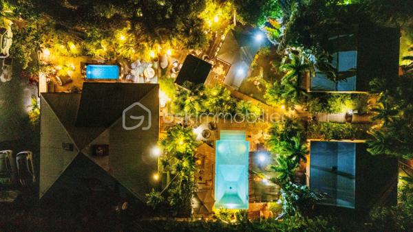 🖼️🪴🏡🌴 ***********EN EXCLUSIVITE *********  Ensemble immobilier d’exception composé d une belle villa T4/5 de 135 m2 avec piscine et d un fonds de commerce proposant 4 gîtes pour une superficie totale de 212 m2 (deux T2 et deux T3) avec piscine et bar sur un terrain arboré de 1600 m2.

Il bénéficie d'un emplacement de premier choix (plusieurs plages renommées ⛱️🐚🌊☀️🏖️🐠 accessibles à pied (bois jolan, Helleux, Pierre et Vacances), dont des spots de surf 😀🏄‍♀️🏄🏻‍♂️🌊, des chemins côtiers promettent aussi de belles balades depuis ce bien). Les commodités sont proches et l'accès à la route nationale est proche.

😊 Les heureux propriétaires, après y avoir mis tous leurs talents de décorateurs / paysagistes / gestionnaires et en avoir fait un petit bijou de raffinement, de convivialité et d’exotisme 🍹🎋🌵🌴, sont appelés par de nouvelles aventures sous d autres horizons 🌍 👀🔎 Ils recherchent maintenant des repreneurs, chanceux de pouvoir faire perdurer leur réussite et qui pourront eux aussi s épanouir dans ce lieu d exception et apaisant au cœur d une nature luxuriante et exceptionnelle (rare sur Grande Terre).

🚪De construction béton, l espace privatif (la villa) et l espace commercial (les 4 gîtes) bénéficient chacun d une entrée indépendante assurant une intimité totale 👍 depuis un grand parking prévu pour 6 voitures.

Vous serez charmés dès l'entrée avec tout d'abord une villa T4/T5 sans vis à vis, composée d'un agréable salon, d'une cuisine équipée semi-ouverte, un cellier, un couloir, 3 chambres, une salle d'eau avec douche et double vasque, puis un wc indépendant. A l'étage : une mezzanine (pouvant être fermée afin d'obtenir une quatrième chambre) avec sa salle d'eau (lavobo, douche et wc). A l'extérieur : une terrasse cosy fermant par des volets roulants anti-cycloniques Somfi, et un magnifique espace extérieur végétalisé, agrémenté d'une piscine de 4m x 2m bordée de pierre de rivière et une douche extérieure ainsi que d'une pergola avec espace détente et coin bar.

Découvrons maintenant l'espace gites... Une belle allée végétalisée vous transportera dans un paradis tropical digne de basse terre ! Sérénité, détente et dépaysement assuré ! Vous découvrirez un espace bar / pergola / espace repas avec ambiance lounge qui vous mènera à la majestueuse piscine agrémentée de deux espaces détente (dont un couvert), avec une douche extérieure.

Puis 4 gites cosy aménagés avec goût et prêts à louer (deux T2 composés d'un salon, une cuisine, une salle d'eau et deux terrasses dont une couverte et deux T3 composés d'un salon, une cuisine, 2 chambres (pour 5 couchages au total), une salle d'eau et deux terrasses dont une couverte.

💘 Vous l aurez compris au vu des photos et des notes extrêmement élevées sur les sites de réservation, ce bien incroyablement abouti et pensé avec finesse, subtilité, raffinement, confort, harmonie dans chaque détail et intelligence, fera le bonheur de ses nouveaux propriétaires. Tous les logements sont vendus meublés et équipés, la décoration et le mobilier sont d une qualité rare et haut de gamme (teck, aluminum où grandes marques se côtoient tels que les canapés Bubble de Roche Bobois, Claire Ambiance, Woodstock, Jura, Dyson, Vorweck, etc...  (les connaisseurs y seront sensibles) 👍 Chaque espace reflète le goût raffiné des propriétaires, qui ont su créer une atmosphère unique où charme et authenticité se mêlent avec justesse.

Les vendeurs sont d'une générosité rare : ils ont poussé leur degré d'exigence à l'extrême pour le confort de leurs hôtes (chaque locatif est équipé d'une machine à café à grains de marque Jura, d'aspirateurs sans traineau tels que Dyson par exemple, les électroménagers sont tous de belles marques. Dans la villa qu'ils occupent, un salon Roche Bobois, de la Sono De Vialet, un robot Thermomix, un robot Kenwood, un airfryer, un sèche linge +++ , des lustres haut de gamme, linge de lit, matelas pour certains d'hôtellerie, robot sans fil pour la piscine.etc... on y trouve aussi de belles pièces d'antiquaires, etc... Tous ces éléments sont inclus dans la vente, les propriétaires ont à coeur de faire bénéficier à leurs successeurs tout le confort et la haute qualité des éléments qui composent ce bien rare. Seuls quelques tableaux signés seront récupérés.

Autres avantages : une citerne tampon de 6000 l alimente tout le site, télésurveillance, vaste parking privé avec portail électrique, micro-station quasiment neuve répondant aux normes actuelles, internet par satellite offrant une connexion irréprochable, porte d'entrée maison en alu, fermeture 4 points, arbres fruitiers (manguier, maracudja, avocatier, goyavier, bananiers. Un abri de jardin en dur borde le parking.

🔵 Pour ce bien d’exception, la fiabilité financière des acquéreurs sera vérifiée avant chaque visite 👍

N'hésitez-pas à me contacter, de préférence via whatsapp ou par mail.