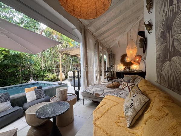 🖼️🪴🏡🌴 ***********EN EXCLUSIVITE *********  Ensemble immobilier d’exception composé d une belle villa T4/5 de 135 m2 avec piscine et d un fonds de commerce proposant 4 gîtes pour une superficie totale de 212 m2 (deux T2 et deux T3) avec piscine et bar sur un terrain arboré de 1600 m2.

Il bénéficie d'un emplacement de premier choix (plusieurs plages renommées ⛱️🐚🌊☀️🏖️🐠 accessibles à pied (bois jolan, Helleux, Pierre et Vacances), dont des spots de surf 😀🏄‍♀️🏄🏻‍♂️🌊, des chemins côtiers promettent aussi de belles balades depuis ce bien). Les commodités sont proches et l'accès à la route nationale est proche.

😊 Les heureux propriétaires, après y avoir mis tous leurs talents de décorateurs / paysagistes / gestionnaires et en avoir fait un petit bijou de raffinement, de convivialité et d’exotisme 🍹🎋🌵🌴, sont appelés par de nouvelles aventures sous d autres horizons 🌍 👀🔎 Ils recherchent maintenant des repreneurs, chanceux de pouvoir faire perdurer leur réussite et qui pourront eux aussi s épanouir dans ce lieu d exception et apaisant au cœur d une nature luxuriante et exceptionnelle (rare sur Grande Terre).

🚪De construction béton, l espace privatif (la villa) et l espace commercial (les 4 gîtes) bénéficient chacun d une entrée indépendante assurant une intimité totale 👍 depuis un grand parking prévu pour 6 voitures.

Vous serez charmés dès l'entrée avec tout d'abord une villa T4/T5 sans vis à vis, composée d'un agréable salon, d'une cuisine équipée semi-ouverte, un cellier, un couloir, 3 chambres, une salle d'eau avec douche et double vasque, puis un wc indépendant. A l'étage : une mezzanine (pouvant être fermée afin d'obtenir une quatrième chambre) avec sa salle d'eau (lavobo, douche et wc). A l'extérieur : une terrasse cosy fermant par des volets roulants anti-cycloniques Somfi, et un magnifique espace extérieur végétalisé, agrémenté d'une piscine de 4m x 2m bordée de pierre de rivière et une douche extérieure ainsi que d'une pergola avec espace détente et coin bar.

Découvrons maintenant l'espace gites... Une belle allée végétalisée vous transportera dans un paradis tropical digne de basse terre ! Sérénité, détente et dépaysement assuré ! Vous découvrirez un espace bar / pergola / espace repas avec ambiance lounge qui vous mènera à la majestueuse piscine agrémentée de deux espaces détente (dont un couvert), avec une douche extérieure.

Puis 4 gites cosy aménagés avec goût et prêts à louer (deux T2 composés d'un salon, une cuisine, une salle d'eau et deux terrasses dont une couverte et deux T3 composés d'un salon, une cuisine, 2 chambres (pour 5 couchages au total), une salle d'eau et deux terrasses dont une couverte.

💘 Vous l aurez compris au vu des photos et des notes extrêmement élevées sur les sites de réservation, ce bien incroyablement abouti et pensé avec finesse, subtilité, raffinement, confort, harmonie dans chaque détail et intelligence, fera le bonheur de ses nouveaux propriétaires. Tous les logements sont vendus meublés et équipés, la décoration et le mobilier sont d une qualité rare et haut de gamme (teck, aluminum où grandes marques se côtoient tels que les canapés Bubble de Roche Bobois, Claire Ambiance, Woodstock, Jura, Dyson, Vorweck, etc...  (les connaisseurs y seront sensibles) 👍 Chaque espace reflète le goût raffiné des propriétaires, qui ont su créer une atmosphère unique où charme et authenticité se mêlent avec justesse.

Les vendeurs sont d'une générosité rare : ils ont poussé leur degré d'exigence à l'extrême pour le confort de leurs hôtes (chaque locatif est équipé d'une machine à café à grains de marque Jura, d'aspirateurs sans traineau tels que Dyson par exemple, les électroménagers sont tous de belles marques. Dans la villa qu'ils occupent, un salon Roche Bobois, de la Sono De Vialet, un robot Thermomix, un robot Kenwood, un airfryer, un sèche linge +++ , des lustres haut de gamme, linge de lit, matelas pour certains d'hôtellerie, robot sans fil pour la piscine.etc... on y trouve aussi de belles pièces d'antiquaires, etc... Tous ces éléments sont inclus dans la vente, les propriétaires ont à coeur de faire bénéficier à leurs successeurs tout le confort et la haute qualité des éléments qui composent ce bien rare. Seuls quelques tableaux signés seront récupérés.

Autres avantages : une citerne tampon de 6000 l alimente tout le site, télésurveillance, vaste parking privé avec portail électrique, micro-station quasiment neuve répondant aux normes actuelles, internet par satellite offrant une connexion irréprochable, porte d'entrée maison en alu, fermeture 4 points, arbres fruitiers (manguier, maracudja, avocatier, goyavier, bananiers. Un abri de jardin en dur borde le parking.

🔵 Pour ce bien d’exception, la fiabilité financière des acquéreurs sera vérifiée avant chaque visite 👍

N'hésitez-pas à me contacter, de préférence via whatsapp ou par mail.