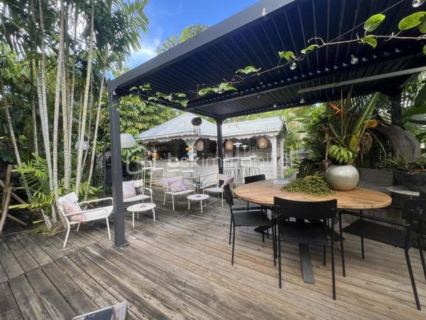 🖼️🪴🏡🌴 ***********EN EXCLUSIVITE *********  Ensemble immobilier d’exception composé d une belle villa T4/5 de 135 m2 avec piscine et d un fonds de commerce proposant 4 gîtes pour une superficie totale de 212 m2 (deux T2 et deux T3) avec piscine et bar sur un terrain arboré de 1600 m2.

Il bénéficie d'un emplacement de premier choix (plusieurs plages renommées ⛱️🐚🌊☀️🏖️🐠 accessibles à pied (bois jolan, Helleux, Pierre et Vacances), dont des spots de surf 😀🏄‍♀️🏄🏻‍♂️🌊, des chemins côtiers promettent aussi de belles balades depuis ce bien). Les commodités sont proches et l'accès à la route nationale est proche.

😊 Les heureux propriétaires, après y avoir mis tous leurs talents de décorateurs / paysagistes / gestionnaires et en avoir fait un petit bijou de raffinement, de convivialité et d’exotisme 🍹🎋🌵🌴, sont appelés par de nouvelles aventures sous d autres horizons 🌍 👀🔎 Ils recherchent maintenant des repreneurs, chanceux de pouvoir faire perdurer leur réussite et qui pourront eux aussi s épanouir dans ce lieu d exception et apaisant au cœur d une nature luxuriante et exceptionnelle (rare sur Grande Terre).

🚪De construction béton, l espace privatif (la villa) et l espace commercial (les 4 gîtes) bénéficient chacun d une entrée indépendante assurant une intimité totale 👍 depuis un grand parking prévu pour 6 voitures.

Vous serez charmés dès l'entrée avec tout d'abord une villa T4/T5 sans vis à vis, composée d'un agréable salon, d'une cuisine équipée semi-ouverte, un cellier, un couloir, 3 chambres, une salle d'eau avec douche et double vasque, puis un wc indépendant. A l'étage : une mezzanine (pouvant être fermée afin d'obtenir une quatrième chambre) avec sa salle d'eau (lavobo, douche et wc). A l'extérieur : une terrasse cosy fermant par des volets roulants anti-cycloniques Somfi, et un magnifique espace extérieur végétalisé, agrémenté d'une piscine de 4m x 2m bordée de pierre de rivière et une douche extérieure ainsi que d'une pergola avec espace détente et coin bar.

Découvrons maintenant l'espace gites... Une belle allée végétalisée vous transportera dans un paradis tropical digne de basse terre ! Sérénité, détente et dépaysement assuré ! Vous découvrirez un espace bar / pergola / espace repas avec ambiance lounge qui vous mènera à la majestueuse piscine agrémentée de deux espaces détente (dont un couvert), avec une douche extérieure.

Puis 4 gites cosy aménagés avec goût et prêts à louer (deux T2 composés d'un salon, une cuisine, une salle d'eau et deux terrasses dont une couverte et deux T3 composés d'un salon, une cuisine, 2 chambres (pour 5 couchages au total), une salle d'eau et deux terrasses dont une couverte.

💘 Vous l aurez compris au vu des photos et des notes extrêmement élevées sur les sites de réservation, ce bien incroyablement abouti et pensé avec finesse, subtilité, raffinement, confort, harmonie dans chaque détail et intelligence, fera le bonheur de ses nouveaux propriétaires. Tous les logements sont vendus meublés et équipés, la décoration et le mobilier sont d une qualité rare et haut de gamme (teck, aluminum où grandes marques se côtoient tels que les canapés Bubble de Roche Bobois, Claire Ambiance, Woodstock, Jura, Dyson, Vorweck, etc...  (les connaisseurs y seront sensibles) 👍 Chaque espace reflète le goût raffiné des propriétaires, qui ont su créer une atmosphère unique où charme et authenticité se mêlent avec justesse.

Les vendeurs sont d'une générosité rare : ils ont poussé leur degré d'exigence à l'extrême pour le confort de leurs hôtes (chaque locatif est équipé d'une machine à café à grains de marque Jura, d'aspirateurs sans traineau tels que Dyson par exemple, les électroménagers sont tous de belles marques. Dans la villa qu'ils occupent, un salon Roche Bobois, de la Sono De Vialet, un robot Thermomix, un robot Kenwood, un airfryer, un sèche linge +++ , des lustres haut de gamme, linge de lit, matelas pour certains d'hôtellerie, robot sans fil pour la piscine.etc... on y trouve aussi de belles pièces d'antiquaires, etc... Tous ces éléments sont inclus dans la vente, les propriétaires ont à coeur de faire bénéficier à leurs successeurs tout le confort et la haute qualité des éléments qui composent ce bien rare. Seuls quelques tableaux signés seront récupérés.

Autres avantages : une citerne tampon de 6000 l alimente tout le site, télésurveillance, vaste parking privé avec portail électrique, micro-station quasiment neuve répondant aux normes actuelles, internet par satellite offrant une connexion irréprochable, porte d'entrée maison en alu, fermeture 4 points, arbres fruitiers (manguier, maracudja, avocatier, goyavier, bananiers. Un abri de jardin en dur borde le parking.

🔵 Pour ce bien d’exception, la fiabilité financière des acquéreurs sera vérifiée avant chaque visite 👍

N'hésitez-pas à me contacter, de préférence via whatsapp ou par mail.