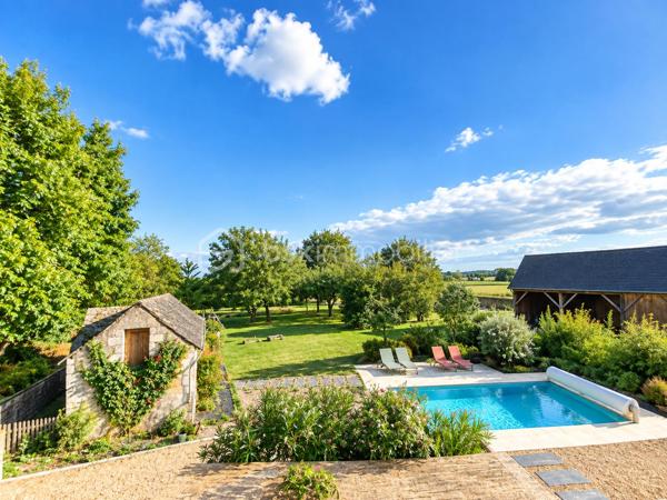 Propriété de charme – Authentique longère rénovée, volumes d’exception et potentiel remarquable

244 m² habitables • Dépendances • Piscine chauffée • Environnement bucolique

L’élégance de l’ancien, sublimée par une rénovation de qualité

À l’abri des regards, dans un environnement préservé où règnent calme et sérénité, se dévoile cette remarquable propriété de caractère, issue de la rénovation soignée d’une ancienne ferme longère.

Ici, le charme opère dès les premiers instants. La noblesse des matériaux anciens, les volumes généreux et la qualité des aménagements composent un ensemble harmonieux, où l’authenticité du bâti dialogue avec le confort d’une vie contemporaine.

Développant actuellement 244 m² habitables, la propriété bénéficie également d’un ensemble de dépendances et de volumes complémentaires offrant un potentiel d’évolution particulièrement séduisant.

Une adresse idéale pour les amoureux de belles demeures, en quête d’un lieu de vie singulier, d’une résidence secondaire de caractère ou d’un projet familial aux multiples possibilités.

Une maison de caractère, entre histoire et raffinement

L’habitation d’origine a su préserver son âme et les témoignages de son passé, tout en bénéficiant d’un très bel état général.

Au rez-de-chaussée, la cuisine indépendante conjugue fonctionnalité et convivialité. Spacieuse, elle invite naturellement aux repas partagés et aux moments de vie en famille.

Dans son prolongement, le salon-bibliothèque séduit par son atmosphère chaleureuse et intemporelle. Son carrelage d’origine, soigneusement préservé, apporte une véritable signature esthétique à cette pièce pleine de charme.

Un authentique escalier de meunier, témoin du passé de la propriété, vient compléter cette ambiance unique et rappelle toute la richesse architecturale de cette ancienne ferme.

Ce niveau propose également :

Une chambre.
Un espace dressing.
Un bureau avec raccordement à la fibre optique, idéal pour le télétravail.
Une salle d’eau.

À l’étage, l’espace nuit se compose de trois chambres, ainsi que d’une salle d’eau et de WC, dans un état irréprochable.

L’ensemble offre une distribution familiale équilibrée, propice à une vie confortable et paisible.

Un potentiel d’agrandissement exceptionnel

L’un des atouts majeurs de cette propriété réside dans ses espaces annexes, offrant de nombreuses perspectives d’aménagement.

Attenante à la maison principale, une ancienne dépendance a fait l’objet d’une réhabilitation complète, donnant naissance à environ 110 m² entièrement neufs, de plain-pied.

Un volume particulièrement intéressant, qui pourra répondre à de nombreux projets : espace de vie indépendant, suite parentale, activité professionnelle, réception ou logement complémentaire.

Au-dessus, un vaste grenier sur dalle béton offre encore près de 100 m² au sol, permettant d’imaginer un aménagement personnalisé selon les envies et les besoins de ses futurs propriétaires.

La propriété dispose également d’un dernier volume d’environ 90 m² à réhabiliter, dont la destination habitable est d’ores et déjà acquise.

Un ensemble rare, qui laisse entrevoir un potentiel d’évolution considérable, tout en conservant l’âme et l’identité de la propriété.

Des extérieurs dessinés comme un véritable art de vivre

À l’extérieur, la propriété révèle un cadre de vie d’une grande qualité.

Les jardins, soigneusement pensés et aménagés par un paysagiste, offrent une succession d’espaces harmonieux où la nature trouve toute sa place.

La piscine constitue une véritable invitation à la détente. Chauffée par pompe à chaleur et équipée d’un tapis motorisé de couverture, elle s’intègre avec élégance dans cet environnement verdoyant.

Au fond du jardin, un joli verger bio prolonge la propriété. Une partie prairie, actuellement dédiée à l’éco-pâturage, apporte une dimension champêtre et authentique à l’ensemble.

Un puits fonctionnel vient compléter les prestations extérieures.

Ici, chaque espace a été conçu pour profiter pleinement des beaux jours, recevoir, se ressourcer ou simplement savourer le calme d’un environnement préservé.

Des dépendances aux multiples possibilités

La propriété bénéficie d’un ensemble de bâtiments annexes qui renforcent encore son caractère et son potentiel :

Un vaste préau permettant d’abriter deux véhicules et de disposer d’un espace de stockage.
Une grange.
Des anciennes soues.
Plusieurs espaces de rangement et de stockage.
Un volume complémentaire d’environ 90 m² à réhabiliter, avec destination habitable acquise.

Ces dépendances offrent une véritable liberté d’usage et pourront accompagner les projets les plus variés : espaces de réception, atelier, stockage, hébergement complémentaire ou développement d’une activité.

Des prestations pensées pour le confort

La propriété bénéficie d’équipements qui conjuguent confort, efficacité et sérénité :

Pompe à chaleur installée en 2017, révisée annuellement.
Poêle à granulés programmable.
Menuiseries aluminium double vitrage.
Assainissement autonome neuf et conforme.
Fibre optique.
Piscine chauffée par pompe à chaleur avec couverture motorisée.
Une propriété rare, pour une vie choisie

Cette ancienne ferme longère offre une qualité de vie particulièrement recherchée : le charme d’une demeure ancienne, la générosité de ses volumes, la richesse de ses dépendances et la douceur d’un environnement rural soigneusement préservé.

Sa vue dégagée, ses jardins paysagers, sa piscine et ses nombreuses possibilités d’évolution en font une propriété aussi séduisante en résidence principale qu’en maison secondaire.

Un lieu de vie authentique et élégant, où chaque détail raconte une histoire et où l’avenir reste à imaginer.

Une propriété de caractère à découvrir sans tarder, pour apprécier pleinement la qualité de sa rénovation, la beauté de ses extérieurs et l’exceptionnel potentiel de cet ensemble.

Dossier complet et visite sur rendez-vous.
