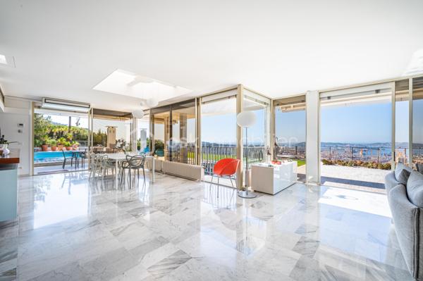 TOULON – FARON | Appartement-villa d’exception avec panorama sur la mer et la rade

Sur les hauteurs du Faron, au sein d’une copropriété de standing à l’architecture remarquable, ce bien rare occupe le dernier niveau et bénéficie d’un cadre de vie privilégié, entre mer, nature et élégance.

Véritable appartement-villa développé de plain-pied, il offre plus de 200 m² habitables sur un ensemble d’environ 1 000 m², en jouissance exclusive. Il conjugue le confort d’un appartement avec l’esprit d’une villa : volumes généreux, circulation fluide sur un seul niveau, accès privatif, extérieurs d’exception et piscine privative.

Dès l’entrée, le regard se laisse naturellement porter vers la Méditerranée. La mer, la rade de Toulon et les reliefs environnants dessinent un décor d’une rare intensité, visible depuis les espaces de réception comme depuis les extérieurs. Ici, le panorama ne se contemple pas seulement : il devient une composante essentielle de l’art de vivre offert par ce lieu unique.

Pensé autour d’un véritable art de vivre indoor-outdoor, ce bien offre une continuité rare entre intérieur et extérieur. Les espaces de réception se prolongent naturellement vers les terrasses, créant une atmosphère lumineuse, ouverte et entièrement tournée vers le panorama.

La pièce de vie, d’une superficie de plus de 75 m², constitue le cœur du bien. Ses belles proportions, sa cheminée et son ouverture direct à l’extérieur en font un espace à la fois élégant, chaleureux et convivial. La cuisine équipée s’inscrit dans le même esprit de confort et de raffinement.

L’espace nuit comprend trois chambres, dont une suite parentale avec salle de bains privative, ainsi qu’une seconde salle de bains et un bureau pouvant être aménagé en quatrième chambre. La distribution préserve l’intimité des espaces privés tout en conservant une circulation harmonieuse.

À l’extérieur, terrasses, jardin, piscine de 5 x 11 mètres, une cuisine d’été avec sanitaire, et une terrasse couverte. Ces espaces prolongent l’appartement comme une véritables pièces de vie à ciel ouvert, idéales pour recevoir, se détendre et de profiter pleinement du climat méditerranéen dans un cadre privilégié face à la mer et à l’une des plus belles rades du monde.

Un accès privatif, plusieurs emplacements de stationnement et deux caves complètent cet ensemble rare sur le marché toulonnais.

Ce bien réunit les atouts d’un appartement de standing — sécurité, dernier étage, vie de plain-pied — et le confort d’une villa, avec ses extérieurs généreux, sa piscine privative, son adresse confidentielle et l’absence de vis-à-vis.

Un bien unique sur le secteur du Faron, destiné à une clientèle recherchant un lieu de vie rare, élégant et résolument tourné vers l’art de vivre méditerranéen.

Des prestations soignées et haut de gamme complètent ce bien d’exception, avec chauffage individuel au gaz, climatisation réversible et système d’arrosage automatique, pour un confort optimal en toute saison.