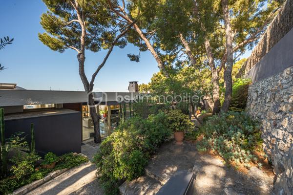 TOULON – FARON | Appartement-villa d’exception avec panorama sur la mer et la rade

Sur les hauteurs du Faron, au sein d’une copropriété de standing à l’architecture remarquable, ce bien rare occupe le dernier niveau et bénéficie d’un cadre de vie privilégié, entre mer, nature et élégance.

Véritable appartement-villa développé de plain-pied, il offre plus de 200 m² habitables sur un ensemble d’environ 1 000 m², en jouissance exclusive. Il conjugue le confort d’un appartement avec l’esprit d’une villa : volumes généreux, circulation fluide sur un seul niveau, accès privatif, extérieurs d’exception et piscine privative.

Dès l’entrée, le regard se laisse naturellement porter vers la Méditerranée. La mer, la rade de Toulon et les reliefs environnants dessinent un décor d’une rare intensité, visible depuis les espaces de réception comme depuis les extérieurs. Ici, le panorama ne se contemple pas seulement : il devient une composante essentielle de l’art de vivre offert par ce lieu unique.

Pensé autour d’un véritable art de vivre indoor-outdoor, ce bien offre une continuité rare entre intérieur et extérieur. Les espaces de réception se prolongent naturellement vers les terrasses, créant une atmosphère lumineuse, ouverte et entièrement tournée vers le panorama.

La pièce de vie, d’une superficie de plus de 75 m², constitue le cœur du bien. Ses belles proportions, sa cheminée et son ouverture direct à l’extérieur en font un espace à la fois élégant, chaleureux et convivial. La cuisine équipée s’inscrit dans le même esprit de confort et de raffinement.

L’espace nuit comprend trois chambres, dont une suite parentale avec salle de bains privative, ainsi qu’une seconde salle de bains et un bureau pouvant être aménagé en quatrième chambre. La distribution préserve l’intimité des espaces privés tout en conservant une circulation harmonieuse.

À l’extérieur, terrasses, jardin, piscine de 5 x 11 mètres, une cuisine d’été avec sanitaire, et une terrasse couverte. Ces espaces prolongent l’appartement comme une véritables pièces de vie à ciel ouvert, idéales pour recevoir, se détendre et de profiter pleinement du climat méditerranéen dans un cadre privilégié face à la mer et à l’une des plus belles rades du monde.

Un accès privatif, plusieurs emplacements de stationnement et deux caves complètent cet ensemble rare sur le marché toulonnais.

Ce bien réunit les atouts d’un appartement de standing — sécurité, dernier étage, vie de plain-pied — et le confort d’une villa, avec ses extérieurs généreux, sa piscine privative, son adresse confidentielle et l’absence de vis-à-vis.

Un bien unique sur le secteur du Faron, destiné à une clientèle recherchant un lieu de vie rare, élégant et résolument tourné vers l’art de vivre méditerranéen.

Des prestations soignées et haut de gamme complètent ce bien d’exception, avec chauffage individuel au gaz, climatisation réversible et système d’arrosage automatique, pour un confort optimal en toute saison.