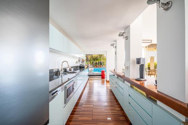 TOULON – FARON | Appartement-villa d’exception avec panorama sur la mer et la rade

Sur les hauteurs du Faron, au sein d’une copropriété de standing à l’architecture remarquable, ce bien rare occupe le dernier niveau et bénéficie d’un cadre de vie privilégié, entre mer, nature et élégance.

Véritable appartement-villa développé de plain-pied, il offre plus de 200 m² habitables sur un ensemble d’environ 1 000 m², en jouissance exclusive. Il conjugue le confort d’un appartement avec l’esprit d’une villa : volumes généreux, circulation fluide sur un seul niveau, accès privatif, extérieurs d’exception et piscine privative.

Dès l’entrée, le regard se laisse naturellement porter vers la Méditerranée. La mer, la rade de Toulon et les reliefs environnants dessinent un décor d’une rare intensité, visible depuis les espaces de réception comme depuis les extérieurs. Ici, le panorama ne se contemple pas seulement : il devient une composante essentielle de l’art de vivre offert par ce lieu unique.

Pensé autour d’un véritable art de vivre indoor-outdoor, ce bien offre une continuité rare entre intérieur et extérieur. Les espaces de réception se prolongent naturellement vers les terrasses, créant une atmosphère lumineuse, ouverte et entièrement tournée vers le panorama.

La pièce de vie, d’une superficie de plus de 75 m², constitue le cœur du bien. Ses belles proportions, sa cheminée et son ouverture direct à l’extérieur en font un espace à la fois élégant, chaleureux et convivial. La cuisine équipée s’inscrit dans le même esprit de confort et de raffinement.

L’espace nuit comprend trois chambres, dont une suite parentale avec salle de bains privative, ainsi qu’une seconde salle de bains et un bureau pouvant être aménagé en quatrième chambre. La distribution préserve l’intimité des espaces privés tout en conservant une circulation harmonieuse.

À l’extérieur, terrasses, jardin, piscine de 5 x 11 mètres, une cuisine d’été avec sanitaire, et une terrasse couverte. Ces espaces prolongent l’appartement comme une véritables pièces de vie à ciel ouvert, idéales pour recevoir, se détendre et de profiter pleinement du climat méditerranéen dans un cadre privilégié face à la mer et à l’une des plus belles rades du monde.

Un accès privatif, plusieurs emplacements de stationnement et deux caves complètent cet ensemble rare sur le marché toulonnais.

Ce bien réunit les atouts d’un appartement de standing — sécurité, dernier étage, vie de plain-pied — et le confort d’une villa, avec ses extérieurs généreux, sa piscine privative, son adresse confidentielle et l’absence de vis-à-vis.

Un bien unique sur le secteur du Faron, destiné à une clientèle recherchant un lieu de vie rare, élégant et résolument tourné vers l’art de vivre méditerranéen.

Des prestations soignées et haut de gamme complètent ce bien d’exception, avec chauffage individuel au gaz, climatisation réversible et système d’arrosage automatique, pour un confort optimal en toute saison.