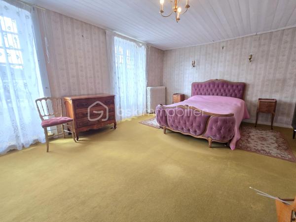 Au cœur du bourg, cette maison en pierre mitoyenne d’un côté offre une belle surface habitable, de nombreux espaces et un potentiel intéressant pour qui souhaite lui redonner une nouvelle vie.
Le rez-de-chaussée s’organise autour d’une entrée desservant une cuisine, une salle à manger, un salon, ainsi qu’une chambre avec point d’eau. Un dégagement mène également à un WC indépendant avec lavabo.
À l’étage, le palier dessert quatre chambres, une salle de bains, une salle d’eau et un second WC indépendant. Au-dessus, un grenier d’environ 35 m² vient compléter l’ensemble et offre une possibilité supplémentaire d’aménagement.
La maison a conservé son intérieur d’origine et nécessite aujourd’hui une rénovation et une remise au goût du jour, notamment pour la cuisine, les pièces d’eau, l’électricité et l’isolation. Le chauffage central au fioul est actuellement fonctionnel et l’installation dessert l’ensemble de la maison. 
À l’extérieur, les dépendances apportent un véritable atout avec une grange d’environ 65 m², une cave de 11,35 m², ainsi qu’un garage d’environ 30 m². Un cabanon, une terrasse et un jardin complètent la propriété, le tout sur un terrain d’environ 796 m².
Une maison qui offre avant tout une belle base et un véritable potentiel de transformation : les volumes sont là, les dépendances aussi, et les futurs propriétaires pourront progressivement la réinventer pour créer un intérieur à leur image.
Un bien à découvrir pour celles et ceux qui recherchent le charme de la pierre, de l’espace et un projet de rénovation à personnaliser.