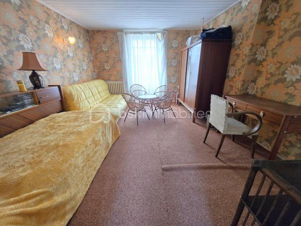 Au cœur du bourg, cette maison en pierre mitoyenne d’un côté offre une belle surface habitable, de nombreux espaces et un potentiel intéressant pour qui souhaite lui redonner une nouvelle vie.
Le rez-de-chaussée s’organise autour d’une entrée desservant une cuisine, une salle à manger, un salon, ainsi qu’une chambre avec point d’eau. Un dégagement mène également à un WC indépendant avec lavabo.
À l’étage, le palier dessert quatre chambres, une salle de bains, une salle d’eau et un second WC indépendant. Au-dessus, un grenier d’environ 35 m² vient compléter l’ensemble et offre une possibilité supplémentaire d’aménagement.
La maison a conservé son intérieur d’origine et nécessite aujourd’hui une rénovation et une remise au goût du jour, notamment pour la cuisine, les pièces d’eau, l’électricité et l’isolation. Le chauffage central au fioul est actuellement fonctionnel et l’installation dessert l’ensemble de la maison. 
À l’extérieur, les dépendances apportent un véritable atout avec une grange d’environ 65 m², une cave de 11,35 m², ainsi qu’un garage d’environ 30 m². Un cabanon, une terrasse et un jardin complètent la propriété, le tout sur un terrain d’environ 796 m².
Une maison qui offre avant tout une belle base et un véritable potentiel de transformation : les volumes sont là, les dépendances aussi, et les futurs propriétaires pourront progressivement la réinventer pour créer un intérieur à leur image.
Un bien à découvrir pour celles et ceux qui recherchent le charme de la pierre, de l’espace et un projet de rénovation à personnaliser.