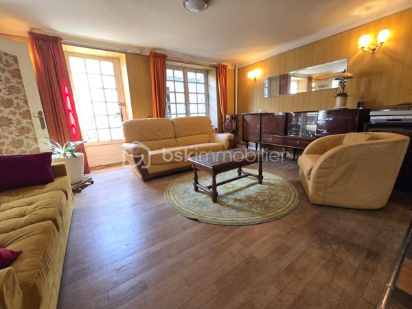Au cœur du bourg, cette maison en pierre mitoyenne d’un côté offre une belle surface habitable, de nombreux espaces et un potentiel intéressant pour qui souhaite lui redonner une nouvelle vie.
Le rez-de-chaussée s’organise autour d’une entrée desservant une cuisine, une salle à manger, un salon, ainsi qu’une chambre avec point d’eau. Un dégagement mène également à un WC indépendant avec lavabo.
À l’étage, le palier dessert quatre chambres, une salle de bains, une salle d’eau et un second WC indépendant. Au-dessus, un grenier d’environ 35 m² vient compléter l’ensemble et offre une possibilité supplémentaire d’aménagement.
La maison a conservé son intérieur d’origine et nécessite aujourd’hui une rénovation et une remise au goût du jour, notamment pour la cuisine, les pièces d’eau, l’électricité et l’isolation. Le chauffage central au fioul est actuellement fonctionnel et l’installation dessert l’ensemble de la maison. 
À l’extérieur, les dépendances apportent un véritable atout avec une grange d’environ 65 m², une cave de 11,35 m², ainsi qu’un garage d’environ 30 m². Un cabanon, une terrasse et un jardin complètent la propriété, le tout sur un terrain d’environ 796 m².
Une maison qui offre avant tout une belle base et un véritable potentiel de transformation : les volumes sont là, les dépendances aussi, et les futurs propriétaires pourront progressivement la réinventer pour créer un intérieur à leur image.
Un bien à découvrir pour celles et ceux qui recherchent le charme de la pierre, de l’espace et un projet de rénovation à personnaliser.