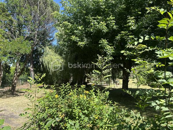 Charme, authenticité et potentiel au cœur d’un environnement privilégié !

Nichée dans un écrin de verdure de plus de 2 000 m², entièrement clôturé, arboré et sans aucun vis-à-vis, cette belle propriété séduira les amateurs de caractère à la recherche d’espace, de calme et d’authenticité.

Dès l’entrée, le charme opère. Les deux vastes pièces de vie, agrémentée d’une cheminée, offrent une atmosphère chaleureuse où les matériaux anciens ont été préservés avec soin : poutres apparentes, murs en pierre et tommettes d’origine confèrent à l’ensemble une âme unique.

La cuisine, généreuse et conviviale, invite aux moments de partage en famille ou entre amis.

À l’étage, l’espace nuit propose quatre chambres, dont une belle suite parentale avec dressing et salle d’eau privative. Une salle de bains indépendante complète ce niveau, ainsi qu’un vaste espace pouvant accueillir une salle de jeux, un bureau ou une chambre supplémentaire selon vos besoins.

Un studio indépendant avec mezzanine attenant constitue un véritable atout : hébergement d’un adolescent, accueil de la famille, activité locative ou professionnelle, les possibilités sont nombreuses.

À l’extérieur, une dépendance en pierre offre un potentiel supplémentaire pour la création d’un carport, d’un atelier ou tout autre projet à définir..

Pour votre confort, le chauffage est assuré par une pompe à chaleur récente installée en 2025. Un garage et une buanderie viennent compléter les prestations de cette propriété pleine de charme.

Une maison rare où authenticité, tranquillité et potentiel se conjuguent parfaitement.

À découvrir sans tarder !