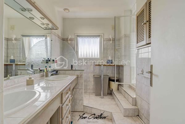 Dans un quartier recherché d’Épinay-sur-Orge, à proximité immédiate des écoles, commerces et transports, découvrez cette maison mitoyenne des deux côtés, construite en 1967, offrant 85 m² habitables répartis sur trois niveaux, ainsi qu’un agréable jardin exposé sud-ouest, sans vis-à-vis.

Dès l’entrée, la maison révèle une organisation particulièrement fonctionnelle, pensée pour faciliter le quotidien d’une famille. Le rez-de-chaussée accueille une entrée, une buanderie, un garde-manger ainsi qu’un garage avec accès direct au jardin.
À l’étage principal, la maison s’ouvre sur un agréable double salon-séjour, accompagné d’une cuisine et d’un WC. Deux porte-fenêtres, depuis le séjour et la cuisine, permettent de rejoindre directement le balcon, véritable prolongement de l’espace de vie. Celui-ci mène ensuite à la terrasse puis au jardin, créant une circulation particulièrement agréable entre intérieur et extérieur.
Le dernier niveau est consacré à l’espace nuit et propose trois chambres, toutes équipées de rangements, ainsi qu’une salle d’eau avec double vasque et WC. Les combles, aménagés et isolés, offrent également un espace de stockage supplémentaire particulièrement appréciable.

À l’extérieur, le jardin profite d’une exposition sud-ouest et de l’absence de vis-à-vis. Sa configuration est particulièrement intéressante puisqu’il dispose de plusieurs accès : depuis le balcon, depuis le garage, mais également par un portillon donnant directement sur le parc situé à l’arrière de la propriété. Deux places de stationnement supplémentaires, aménagées en pavés, viennent compléter les possibilités de stationnement.

La maison a fait l’objet de nombreux travaux au fil des années, avec une volonté constante de l’entretenir et de l’améliorer. En 2016, plusieurs éléments importants ont été rénovés : les fenêtres et les radiateurs ont été remplacés, la cuisine a été refaite, tandis que le parquet a été poncé et vitrifié et que les murs ont été entièrement repeints.
En 2019, les extérieurs ont à leur tour été valorisés avec la création de la terrasse. L’allée de stationnement en pavés a également été réalisée cette année-là. En 2020, la maison a bénéficié d’un ravalement complet, ainsi que d’un nettoyage de la toiture. L’aménagement des combles, accompagnés de leur isolation, ont aussi été effectués en 2019.
Plus récemment, en 2025, plusieurs améliorations ont encore été apportées avec le remplacement de la porte de garage, de la porte d’entrée et de plusieurs fenêtres, mais également l’isolation du sol du garage et la création d’une nouvelle allée en pavés dans le jardin.

La maison est par ailleurs équipée d’une chaudière gaz Viessmann entretenue chaque année, et bénéficie de nombreux espaces permettant de répondre facilement aux besoins de stockage du quotidien : buanderie, garage, combles aménagés et rangements dans chacune des chambres.

L’emplacement est certainement l’un des atouts majeurs de cette maison. Installée dans un environnement résidentiel recherché, elle permet de rejoindre très facilement les commodités du quotidien sans avoir systématiquement besoin de prendre la voiture.
Le collège se trouve à seulement quelques minutes à pied, tandis que les écoles sont accessibles en une dizaine de minutes. En environ cinq minutes, vous rejoindrez également tous les commerces de proximité. La gare est quant à elle située à environ quinze/vingt minutes à pied (RER C et T12), permettant de profiter facilement des transports en commun.
En voiture, l’A6 est à seulement quelques minutes et les principaux centres commerciaux se rejoignent en une dizaine de minutes.
Un emplacement particulièrement adapté à une vie de famille, avec écoles, commerces, transports, espaces verts et services accessibles rapidement, tout en profitant d’un environnement résidentiel calme.

Une maison fonctionnelle, régulièrement entretenue et idéalement située, à découvrir sans tarder à Épinay-sur-Orge.