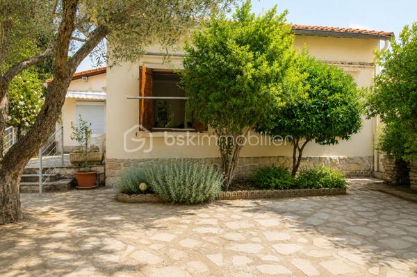 Située Route de Beaucaire à Nîmes, dans un renfoncement qui la préserve des nuisances de la circulation, cette maison traditionnelle de plain-pied d'environ 83 m² offre un cadre de vie agréable, à proximité immédiate des commerces, des écoles et de toutes les commodités.

Implantée sur un terrain arboré de 439 m², sans vis-à-vis, elle séduira les amateurs de rénovation souhaitant créer un intérieur à leur image.

La maison se compose de :

Une cuisine indépendante,
Un vaste salon-séjour lumineux,
Deux chambres,
Une salle de bains,
Un WC indépendant.

À l'extérieur, vous profiterez d'une agréable terrasse donnant sur un jardin verdoyant, d'un garage attenant aménagé, d'un abri de jardin ainsi que d'un forage, un véritable atout pour l'entretien des espaces extérieurs.

Côté équipements, la maison dispose de :

Menuiseries bois avec double vitrage,
Climatisation dans le séjour ainsi que dans une chambre.

Des travaux de rénovation sont à prévoir, permettant de moderniser les prestations et de révéler tout le potentiel de cette construction traditionnelle, reconnue pour sa solidité.

Son implantation en retrait de la route, son jardin arboré sans vis-à-vis, ses dépendances et sa proximité avec toutes les commodités en font une belle opportunité, que ce soit pour une résidence principale ou un investissement.

Une maison offrant de belles bases et un fort potentiel de valorisation après rénovation.

N'attendez plus pour venir la découvrir !