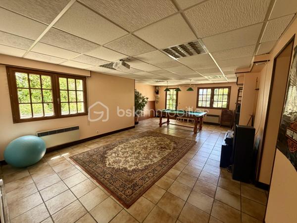 Nous vous proposons en exclusivité cette remarquable maison familiale atypique et polyvalente, offrant des volumes généreux et de nombreuses possibilités d’aménagement, idéalement implantée sur un terrain arboré de plus de 1 000 m².

🏡 Espace principal (accès par escaliers) :
Le cœur de la maison s’articule autour d’un séjour double lumineux ouvrant sur un balcon, agrémenté d’un poêle à bois pour une ambiance chaleureuse. La cuisine ouverte entièrement aménagée et équipée, prolongée par un cellier, en fait un espace de vie idéal pour recevoir en famille. Cet étage comprend également une suite parentale ainsi qu’une grande pièce modulable pouvant servir de bureau ou de chambre supplémentaire.

🛏️ Étage supérieur :
Quatre chambres dont deux avec placards intégrés, et une salle de bains avec WC semi-indépendant complètent cet espace nuit généreux et fonctionnel.

🔑 Rez-de-chaussée – Une vraie valeur ajoutée :
Le niveau inférieur offre une véranda, un placard d’entrée et un local technique. Le garage double avec deux ateliers attenants séduira les amateurs de bricolage ou les professionnels.

Point fort du bien : un appartement T2 totalement indépendant — actuellement loué 900 €/mois — composé d’un séjour, d’une cuisine, d’une chambre, d’une salle d’eau, de WC indépendants et d’un bureau aménagé avec sauna. Idéal pour un projet familial (logement d’un proche) ou pour optimiser la rentabilité locative.

🌿 Extérieur :
Le jardin dispose de deux puits et d’une réserve d’eau, ainsi que d’une dépendance divisée en trois espaces distincts à l’arrière de la propriété — offrant de multiples usages selon vos besoins.

⚙️ Prestations techniques :
Bien entretenu et régulièrement mis à jour :
	•	Tableau électrique triphasé
	•	VMC double flux
	•	Radiateurs connectés pilotables par zone
	•	Ballon thermodynamique de 300 L (remplacé en 2019)
	•	Fibre optique
	•	Dalles béton au RDC et R+1 — ossature bois au R+2

Votre conseillère est disponible 7j/7.
📞 Contactez-nous dès maintenant pour programmer votre visite.
