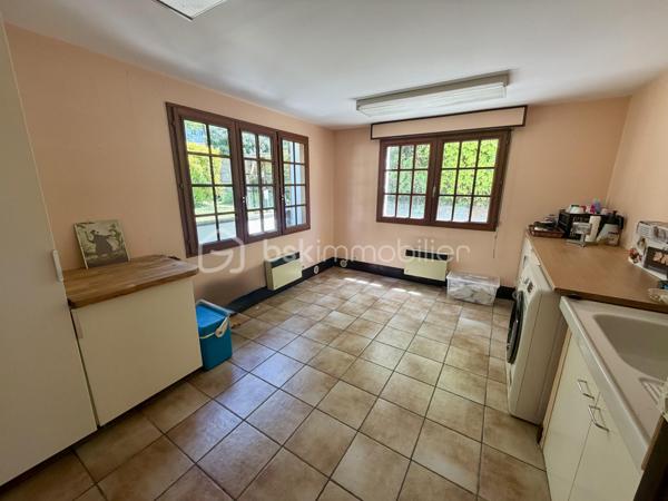 Nous vous proposons en exclusivité cette remarquable maison familiale atypique et polyvalente, offrant des volumes généreux et de nombreuses possibilités d’aménagement, idéalement implantée sur un terrain arboré de plus de 1 000 m².

🏡 Espace principal (accès par escaliers) :
Le cœur de la maison s’articule autour d’un séjour double lumineux ouvrant sur un balcon, agrémenté d’un poêle à bois pour une ambiance chaleureuse. La cuisine ouverte entièrement aménagée et équipée, prolongée par un cellier, en fait un espace de vie idéal pour recevoir en famille. Cet étage comprend également une suite parentale ainsi qu’une grande pièce modulable pouvant servir de bureau ou de chambre supplémentaire.

🛏️ Étage supérieur :
Quatre chambres dont deux avec placards intégrés, et une salle de bains avec WC semi-indépendant complètent cet espace nuit généreux et fonctionnel.

🔑 Rez-de-chaussée – Une vraie valeur ajoutée :
Le niveau inférieur offre une véranda, un placard d’entrée et un local technique. Le garage double avec deux ateliers attenants séduira les amateurs de bricolage ou les professionnels.

Point fort du bien : un appartement T2 totalement indépendant — actuellement loué 900 €/mois — composé d’un séjour, d’une cuisine, d’une chambre, d’une salle d’eau, de WC indépendants et d’un bureau aménagé avec sauna. Idéal pour un projet familial (logement d’un proche) ou pour optimiser la rentabilité locative.

🌿 Extérieur :
Le jardin dispose de deux puits et d’une réserve d’eau, ainsi que d’une dépendance divisée en trois espaces distincts à l’arrière de la propriété — offrant de multiples usages selon vos besoins.

⚙️ Prestations techniques :
Bien entretenu et régulièrement mis à jour :
	•	Tableau électrique triphasé
	•	VMC double flux
	•	Radiateurs connectés pilotables par zone
	•	Ballon thermodynamique de 300 L (remplacé en 2019)
	•	Fibre optique
	•	Dalles béton au RDC et R+1 — ossature bois au R+2

Votre conseillère est disponible 7j/7.
📞 Contactez-nous dès maintenant pour programmer votre visite.
