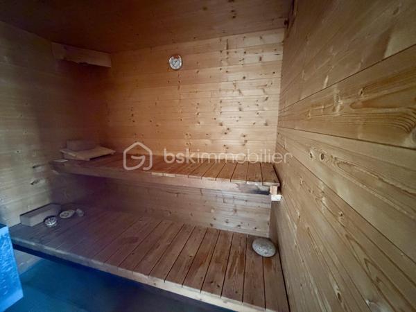 Nous vous proposons en exclusivité cette remarquable maison familiale atypique et polyvalente, offrant des volumes généreux et de nombreuses possibilités d’aménagement, idéalement implantée sur un terrain arboré de plus de 1 000 m².

🏡 Espace principal (accès par escaliers) :
Le cœur de la maison s’articule autour d’un séjour double lumineux ouvrant sur un balcon, agrémenté d’un poêle à bois pour une ambiance chaleureuse. La cuisine ouverte entièrement aménagée et équipée, prolongée par un cellier, en fait un espace de vie idéal pour recevoir en famille. Cet étage comprend également une suite parentale ainsi qu’une grande pièce modulable pouvant servir de bureau ou de chambre supplémentaire.

🛏️ Étage supérieur :
Quatre chambres dont deux avec placards intégrés, et une salle de bains avec WC semi-indépendant complètent cet espace nuit généreux et fonctionnel.

🔑 Rez-de-chaussée – Une vraie valeur ajoutée :
Le niveau inférieur offre une véranda, un placard d’entrée et un local technique. Le garage double avec deux ateliers attenants séduira les amateurs de bricolage ou les professionnels.

Point fort du bien : un appartement T2 totalement indépendant — actuellement loué 900 €/mois — composé d’un séjour, d’une cuisine, d’une chambre, d’une salle d’eau, de WC indépendants et d’un bureau aménagé avec sauna. Idéal pour un projet familial (logement d’un proche) ou pour optimiser la rentabilité locative.

🌿 Extérieur :
Le jardin dispose de deux puits et d’une réserve d’eau, ainsi que d’une dépendance divisée en trois espaces distincts à l’arrière de la propriété — offrant de multiples usages selon vos besoins.

⚙️ Prestations techniques :
Bien entretenu et régulièrement mis à jour :
	•	Tableau électrique triphasé
	•	VMC double flux
	•	Radiateurs connectés pilotables par zone
	•	Ballon thermodynamique de 300 L (remplacé en 2019)
	•	Fibre optique
	•	Dalles béton au RDC et R+1 — ossature bois au R+2

Votre conseillère est disponible 7j/7.
📞 Contactez-nous dès maintenant pour programmer votre visite.