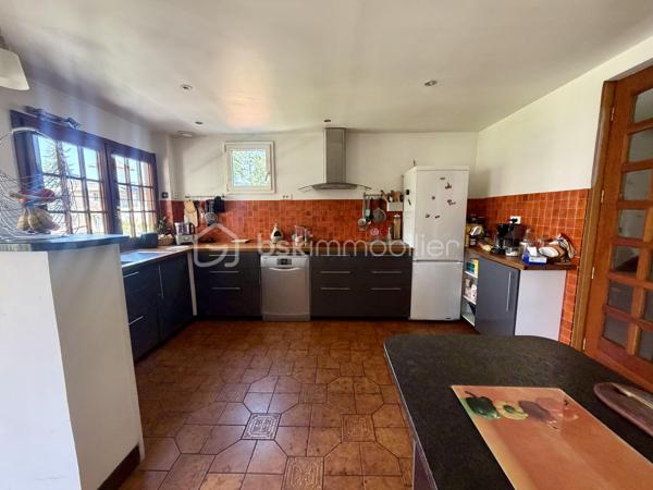 Nous vous proposons en exclusivité cette remarquable maison familiale atypique et polyvalente, offrant des volumes généreux et de nombreuses possibilités d’aménagement, idéalement implantée sur un terrain arboré de plus de 1 000 m².

🏡 Espace principal (accès par escaliers) :
Le cœur de la maison s’articule autour d’un séjour double lumineux ouvrant sur un balcon, agrémenté d’un poêle à bois pour une ambiance chaleureuse. La cuisine ouverte entièrement aménagée et équipée, prolongée par un cellier, en fait un espace de vie idéal pour recevoir en famille. Cet étage comprend également une suite parentale ainsi qu’une grande pièce modulable pouvant servir de bureau ou de chambre supplémentaire.

🛏️ Étage supérieur :
Quatre chambres dont deux avec placards intégrés, et une salle de bains avec WC semi-indépendant complètent cet espace nuit généreux et fonctionnel.

🔑 Rez-de-chaussée – Une vraie valeur ajoutée :
Le niveau inférieur offre une véranda, un placard d’entrée et un local technique. Le garage double avec deux ateliers attenants séduira les amateurs de bricolage ou les professionnels.

Point fort du bien : un appartement T2 totalement indépendant — actuellement loué 900 €/mois — composé d’un séjour, d’une cuisine, d’une chambre, d’une salle d’eau, de WC indépendants et d’un bureau aménagé avec sauna. Idéal pour un projet familial (logement d’un proche) ou pour optimiser la rentabilité locative.

🌿 Extérieur :
Le jardin dispose de deux puits et d’une réserve d’eau, ainsi que d’une dépendance divisée en trois espaces distincts à l’arrière de la propriété — offrant de multiples usages selon vos besoins.

⚙️ Prestations techniques :
Bien entretenu et régulièrement mis à jour :
	•	Tableau électrique triphasé
	•	VMC double flux
	•	Radiateurs connectés pilotables par zone
	•	Ballon thermodynamique de 300 L (remplacé en 2019)
	•	Fibre optique
	•	Dalles béton au RDC et R+1 — ossature bois au R+2

Votre conseillère est disponible 7j/7.
📞 Contactez-nous dès maintenant pour programmer votre visite.