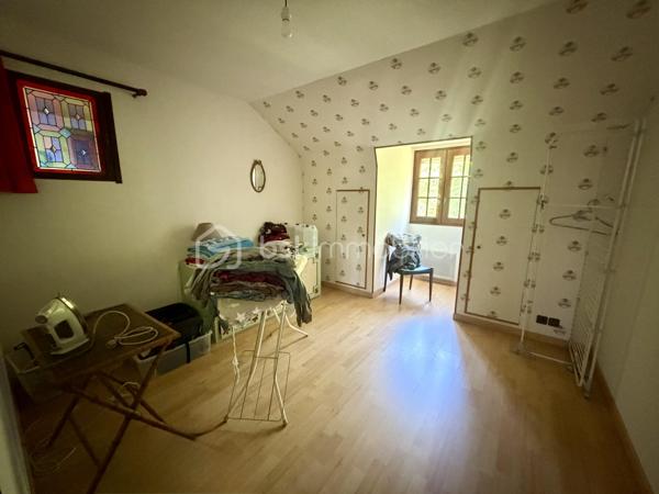 Nous vous proposons en exclusivité cette remarquable maison familiale atypique et polyvalente, offrant des volumes généreux et de nombreuses possibilités d’aménagement, idéalement implantée sur un terrain arboré de plus de 1 000 m².

🏡 Espace principal (accès par escaliers) :
Le cœur de la maison s’articule autour d’un séjour double lumineux ouvrant sur un balcon, agrémenté d’un poêle à bois pour une ambiance chaleureuse. La cuisine ouverte entièrement aménagée et équipée, prolongée par un cellier, en fait un espace de vie idéal pour recevoir en famille. Cet étage comprend également une suite parentale ainsi qu’une grande pièce modulable pouvant servir de bureau ou de chambre supplémentaire.

🛏️ Étage supérieur :
Quatre chambres dont deux avec placards intégrés, et une salle de bains avec WC semi-indépendant complètent cet espace nuit généreux et fonctionnel.

🔑 Rez-de-chaussée – Une vraie valeur ajoutée :
Le niveau inférieur offre une véranda, un placard d’entrée et un local technique. Le garage double avec deux ateliers attenants séduira les amateurs de bricolage ou les professionnels.

Point fort du bien : un appartement T2 totalement indépendant — actuellement loué 900 €/mois — composé d’un séjour, d’une cuisine, d’une chambre, d’une salle d’eau, de WC indépendants et d’un bureau aménagé avec sauna. Idéal pour un projet familial (logement d’un proche) ou pour optimiser la rentabilité locative.

🌿 Extérieur :
Le jardin dispose de deux puits et d’une réserve d’eau, ainsi que d’une dépendance divisée en trois espaces distincts à l’arrière de la propriété — offrant de multiples usages selon vos besoins.

⚙️ Prestations techniques :
Bien entretenu et régulièrement mis à jour :
	•	Tableau électrique triphasé
	•	VMC double flux
	•	Radiateurs connectés pilotables par zone
	•	Ballon thermodynamique de 300 L (remplacé en 2019)
	•	Fibre optique
	•	Dalles béton au RDC et R+1 — ossature bois au R+2

Votre conseillère est disponible 7j/7.
📞 Contactez-nous dès maintenant pour programmer votre visite.