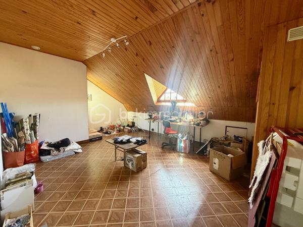 Nous vous proposons en exclusivité cette remarquable maison familiale atypique et polyvalente, offrant des volumes généreux et de nombreuses possibilités d’aménagement, idéalement implantée sur un terrain arboré de plus de 1 000 m².

🏡 Espace principal (accès par escaliers) :
Le cœur de la maison s’articule autour d’un séjour double lumineux ouvrant sur un balcon, agrémenté d’un poêle à bois pour une ambiance chaleureuse. La cuisine ouverte entièrement aménagée et équipée, prolongée par un cellier, en fait un espace de vie idéal pour recevoir en famille. Cet étage comprend également une suite parentale ainsi qu’une grande pièce modulable pouvant servir de bureau ou de chambre supplémentaire.

🛏️ Étage supérieur :
Quatre chambres dont deux avec placards intégrés, et une salle de bains avec WC semi-indépendant complètent cet espace nuit généreux et fonctionnel.

🔑 Rez-de-chaussée – Une vraie valeur ajoutée :
Le niveau inférieur offre une véranda, un placard d’entrée et un local technique. Le garage double avec deux ateliers attenants séduira les amateurs de bricolage ou les professionnels.

Point fort du bien : un appartement T2 totalement indépendant — actuellement loué 900 €/mois — composé d’un séjour, d’une cuisine, d’une chambre, d’une salle d’eau, de WC indépendants et d’un bureau aménagé avec sauna. Idéal pour un projet familial (logement d’un proche) ou pour optimiser la rentabilité locative.

🌿 Extérieur :
Le jardin dispose de deux puits et d’une réserve d’eau, ainsi que d’une dépendance divisée en trois espaces distincts à l’arrière de la propriété — offrant de multiples usages selon vos besoins.

⚙️ Prestations techniques :
Bien entretenu et régulièrement mis à jour :
	•	Tableau électrique triphasé
	•	VMC double flux
	•	Radiateurs connectés pilotables par zone
	•	Ballon thermodynamique de 300 L (remplacé en 2019)
	•	Fibre optique
	•	Dalles béton au RDC et R+1 — ossature bois au R+2

Votre conseillère est disponible 7j/7.
📞 Contactez-nous dès maintenant pour programmer votre visite.