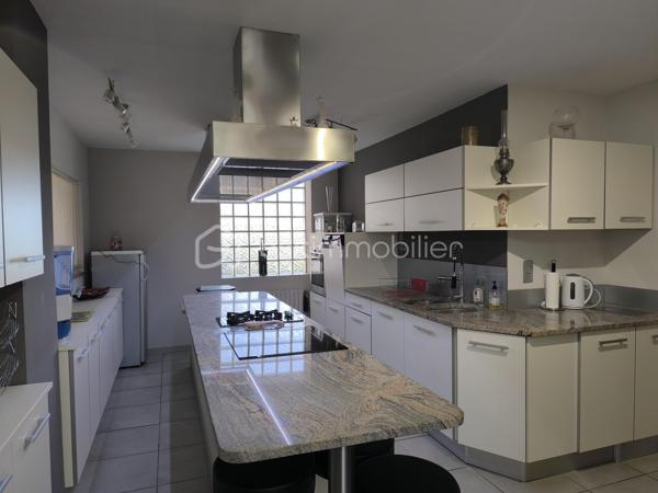 RARE! Une grande maison familiale en plein centre-ville de Parigné L’Evêque, proche des transports, écoles et commerces! Diagnostic en A.

La maison comprend au RDC une entrée – véranda, une salle à manger, un séjour avec une cheminée avec le foyer ouvert, une belle cuisine de 22 m² aménagée et équipée, trois chambres dont une avec des placards dressing, une salle de bain avec une baignoire et une douche, un WC séparé. Nombreux rangements complémentaires dans le couloir.

A l’étage vous avez deux chambres de plus, un bureau, une grande salle d’eau et un WC séparé, des rangements.

Au rez-de-jardin de la maison se trouvent une cuisine d’été, deux salles d’eau et deux WC séparés ainsi que deux pièces pouvant servir deux chambres complémentaires (14 et 11 m²) et une véranda.

Sous-sol avec plusieurs pièces de stockage, une cave, une pièce technique et même un vide-ordure permettant de remplir vos sacs directement de la cuisine au sous-sol.

Le rez-de-jardin et le rdc sont à rafraîchir, l’étage a été aménagé récemment, aucuns travaux à prévoir dans cette partie.

Le chauffage de la maison est assuré par la pompe à chaleur neuve (!), avec des radiateurs électriques en complément à l’étage. L’isolation extérieure, le système de VMC autoréglable, menuiseries double vitrage PVC sont là pour votre confort énergétique (DPE en A !)

Le bien est complété par un double garage à côté de la maison avec la possibilité de plusieurs rangements et même un pont pour les amoureux aux voitures.

Sur le grand terrain autours de la maison vous avez également une grande cave, une douche d’été et une piscine sous abri (le liner à remplacer).

Une belle opportunité, n’hésitez pas à me contacter pour des renseignements complémentaires et une visite!