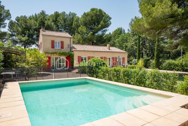 À seulement quelques minutes du centre du village d’Éguilles et à proximité immédiate d’Aix-en-Provence, cette propriété offre avant tout ce qui devient aujourd’hui particulièrement recherché : le calme, l’espace et un environnement naturel préservé.

Implantée sur un magnifique terrain arboré de plus de 4 200 m², entièrement clôturé avec arrosage automatique alimenté par le Canal de Provence, la maison bénéficie d’un cadre verdoyant, bucolique et sans nuisance.

UNE MAISON FAMILIALE PLEINE DE CHARME
La maison principale développe environ 143 m² habitables et propose une organisation fonctionnelle permettant une vie de plain-pied.
Elle se compose notamment :
d’un salon traversant lumineux de 27 m²,
d’une salle à manger avec cheminée ouverte de 29 m²,
d’une cuisine indépendante,
de trois chambres,
d’une salle d’eau,
puis à l’étage, d’une suite parentale lumineuse de 24 m² avec salle de bain privative et toilettes.

DES ESPACES ANNEXES AUX MULTIPLES POSSIBILITÉS
La propriété dispose également :
d’une première annexe de 20 m²,
d’une seconde annexe de 24 m², idéales pour accueillir famille et amis ou créer un espace de travail, de télétravail ou de loisirs,
d’un atelier de 16 m²,
ainsi que d’un abri voitures.
La surface utile totale avoisine ainsi les 185 m².

UNE MAISON À RÉINVENTER
Cette propriété possède une véritable âme et beaucoup de caractère.
Des travaux de rénovation importants seront à prévoir, mais le potentiel du lieu, son environnement exceptionnel et ses possibilités d’évolution en font une belle opportunité pour des acquéreurs en recherche d’un projet de vie à personnaliser.

Possibilités d’extension validées par l’urbanisme :
surélévation d’environ 40 m²,
ou extension au sol d’environ 30 m² attenants à la maison.

UN EXTÉRIEUR PRIVILÉGIÉ
Le terrain accueille :
une piscine 6 x 4 m,
plusieurs espaces de détente à l’ombre des arbres.
Un lieu paisible et inspirant, à seulement quelques minutes d’Aix-en-Provence.

UNE SITUATION IDÉALE
À 2 km du centre d’Éguilles et des commerces,
À proximité des bus scolaires et des lignes de ville,
À 10 minutes d’Aix-en-Provence,
À 20 minutes de la gare TGV,
À 30 minutes de l’aéroport.

UN BIEN RARE PAR SON ENVIRONNEMENT
Une propriété pleine de potentiel, idéale pour ceux qui souhaitent redonner vie à une maison de caractère dans un cadre naturel particulièrement recherché.
