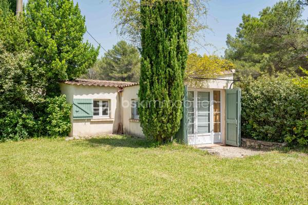 À seulement quelques minutes du centre du village d’Éguilles et à proximité immédiate d’Aix-en-Provence, cette propriété offre avant tout ce qui devient aujourd’hui particulièrement recherché : le calme, l’espace et un environnement naturel préservé.

Implantée sur un magnifique terrain arboré de plus de 4 200 m², entièrement clôturé avec arrosage automatique alimenté par le Canal de Provence, la maison bénéficie d’un cadre verdoyant, bucolique et sans nuisance.

UNE MAISON FAMILIALE PLEINE DE CHARME
La maison principale développe environ 143 m² habitables et propose une organisation fonctionnelle permettant une vie de plain-pied.
Elle se compose notamment :
d’un salon traversant lumineux de 27 m²,
d’une salle à manger avec cheminée ouverte de 29 m²,
d’une cuisine indépendante,
de trois chambres,
d’une salle d’eau,
puis à l’étage, d’une suite parentale lumineuse de 24 m² avec salle de bain privative et toilettes.

DES ESPACES ANNEXES AUX MULTIPLES POSSIBILITÉS
La propriété dispose également :
d’une première annexe de 20 m²,
d’une seconde annexe de 24 m², idéales pour accueillir famille et amis ou créer un espace de travail, de télétravail ou de loisirs,
d’un atelier de 16 m²,
ainsi que d’un abri voitures.
La surface utile totale avoisine ainsi les 185 m².

UNE MAISON À RÉINVENTER
Cette propriété possède une véritable âme et beaucoup de caractère.
Des travaux de rénovation importants seront à prévoir, mais le potentiel du lieu, son environnement exceptionnel et ses possibilités d’évolution en font une belle opportunité pour des acquéreurs en recherche d’un projet de vie à personnaliser.

Possibilités d’extension validées par l’urbanisme :
surélévation d’environ 40 m²,
ou extension au sol d’environ 30 m² attenants à la maison.

UN EXTÉRIEUR PRIVILÉGIÉ
Le terrain accueille :
une piscine 6 x 4 m,
plusieurs espaces de détente à l’ombre des arbres.
Un lieu paisible et inspirant, à seulement quelques minutes d’Aix-en-Provence.

UNE SITUATION IDÉALE
À 2 km du centre d’Éguilles et des commerces,
À proximité des bus scolaires et des lignes de ville,
À 10 minutes d’Aix-en-Provence,
À 20 minutes de la gare TGV,
À 30 minutes de l’aéroport.

UN BIEN RARE PAR SON ENVIRONNEMENT
Une propriété pleine de potentiel, idéale pour ceux qui souhaitent redonner vie à une maison de caractère dans un cadre naturel particulièrement recherché.