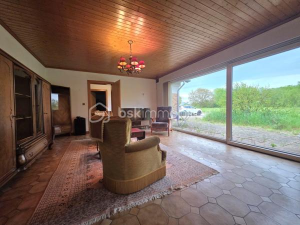 Située sur la commune de Harskirchen, cette propriété rare offre un fort potentiel sur un vaste terrain de 71,82 ares, idéal pour les amoureux d’espace, ou les investisseurs en quête d’un projet à valoriser.

La maison principale, de plain-pied, développe une surface généreuse de 320 m². Elle se distingue par ses volumes spacieux et sa configuration modulable, laissant entrevoir de nombreuses possibilités d’aménagement. Classée en D au diagnostic de performance énergétique, elle nécessite quelques travaux de rafraîchissement pour révéler tout son potentiel.

La toiture, refaite il y a une quinzaine d’années, est en excellent état, constituant un atout majeur pour ce type de bien. À l’étage, une dalle existante ainsi que des combles aménageables (jusqu'à 200m²) offrent des perspectives d’extension ou de transformation particulièrement intéressantes.

Une dépendance d’environ 80 m² complète l’ensemble, pouvant être exploitée en atelier, espace de stockage ou logement annexe selon vos besoins.

Ce bien présente une opportunité idéale pour un projet d’investissement : la configuration permet aisément la création de deux lots de plain-pied pouvant profiter un à projet bi-familial par exemple, tout en conservant de beaux espaces extérieurs.

Possibilité de créer une parcelle constructible indépendante de 17ares environ, à proximité immédiate de la maison.

Un bien aux multiples possibilités, à découvrir sans tarder pour concrétiser vos projets immobiliers.