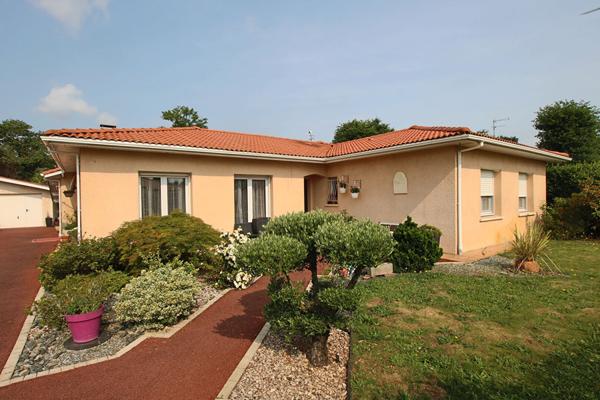 Plain-pied 4 chambres avec jardin paysagé et garage, proche commodités.