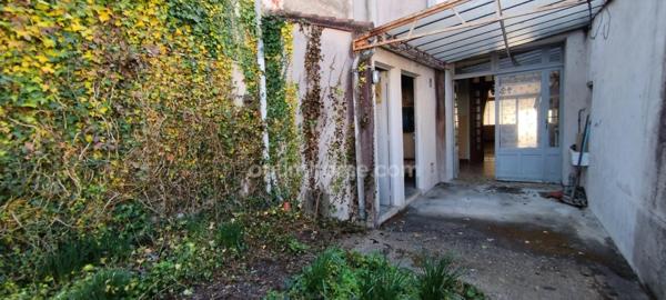 AIGRE. Immeuble avec local professionnel de 103 m², petite cour et garage 2 places. Jardin.