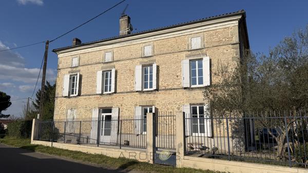 Maison de maître en pierre avec dépendances et jardin clos arboré.
