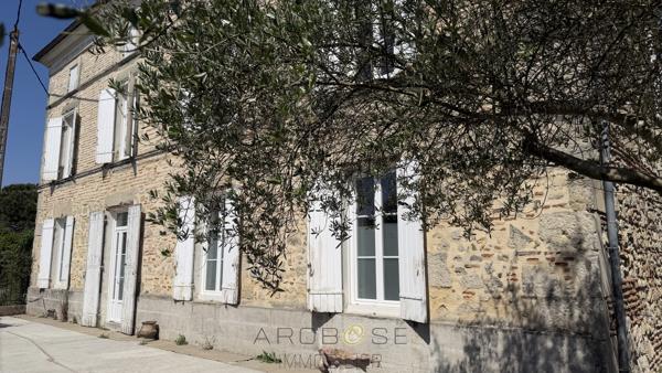 Maison de maître en pierre avec dépendances et jardin clos arboré.
