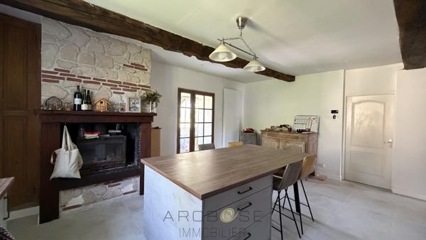 Maison de maître en pierre avec dépendances et jardin clos arboré.