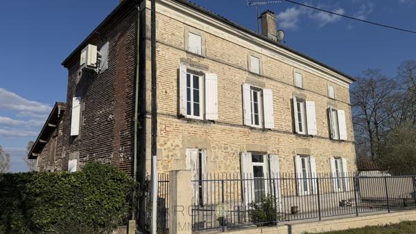 Maison de maître en pierre avec dépendances et jardin clos arboré.
